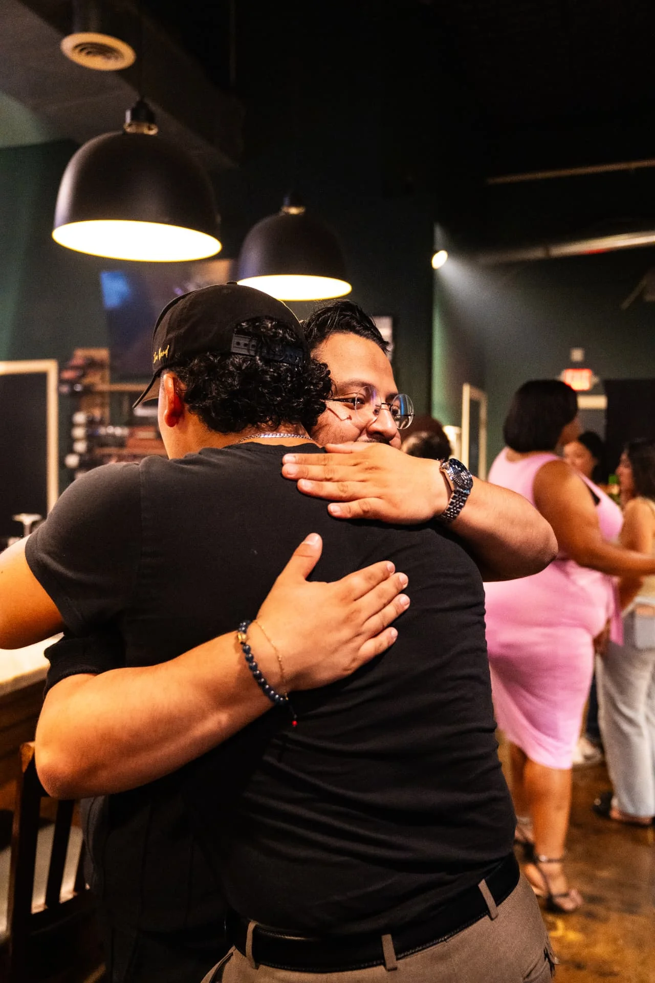 Regulars greeting each other on a busy night at Ash & Barrel