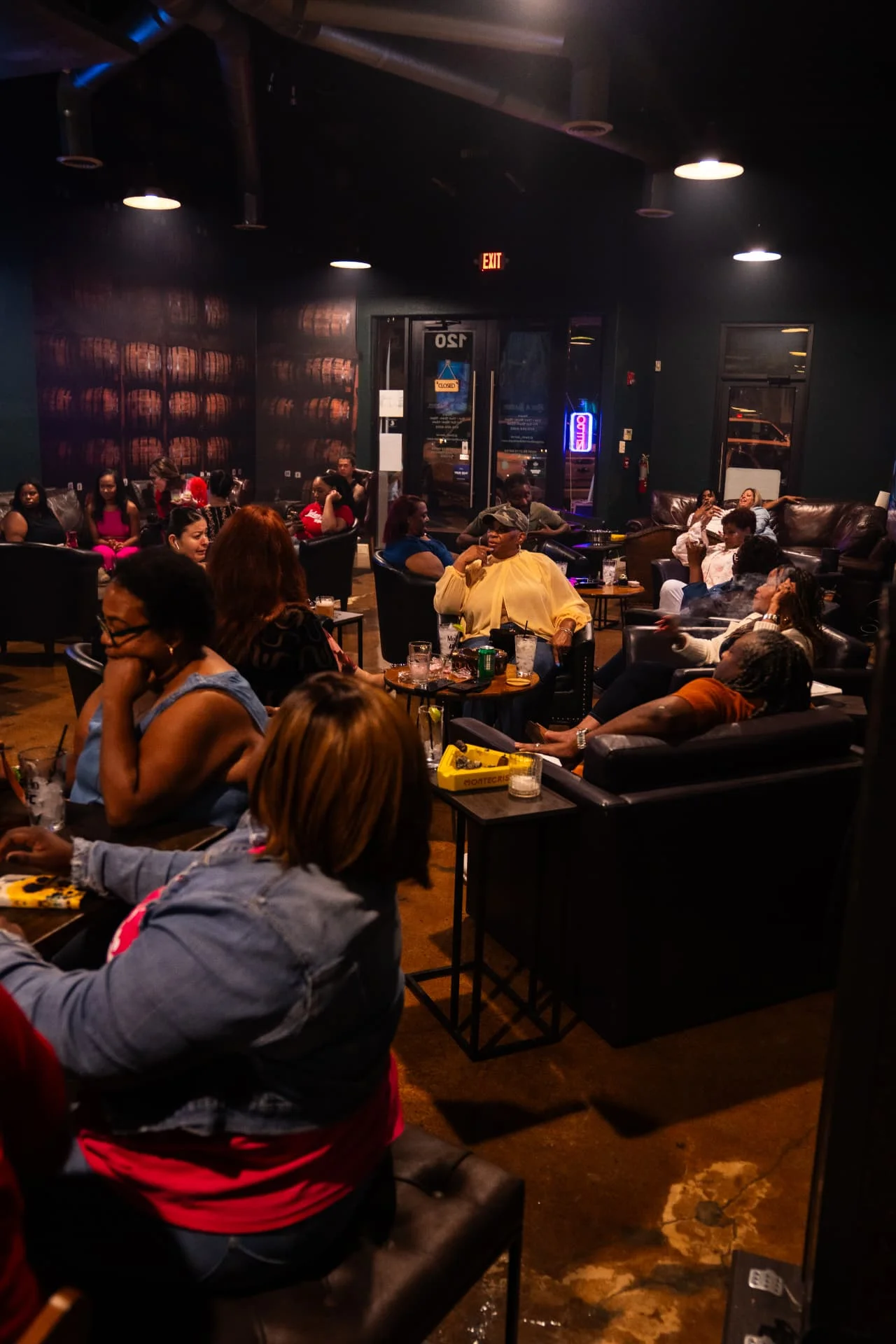 Guests relaxing in leather lounge chairs at Ash & Barrel