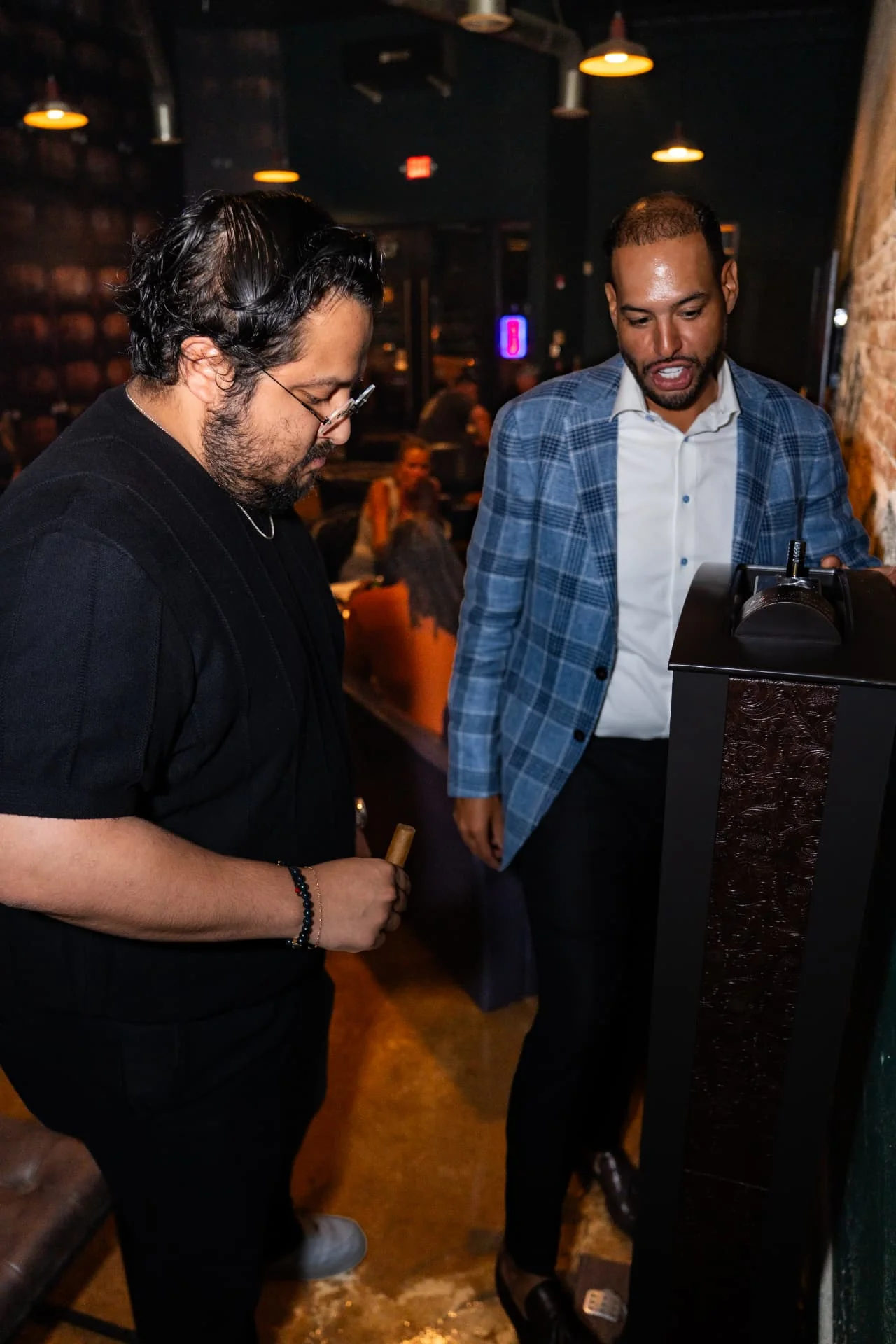 Guests talking cigars beside the ash tower at Ash & Barrel