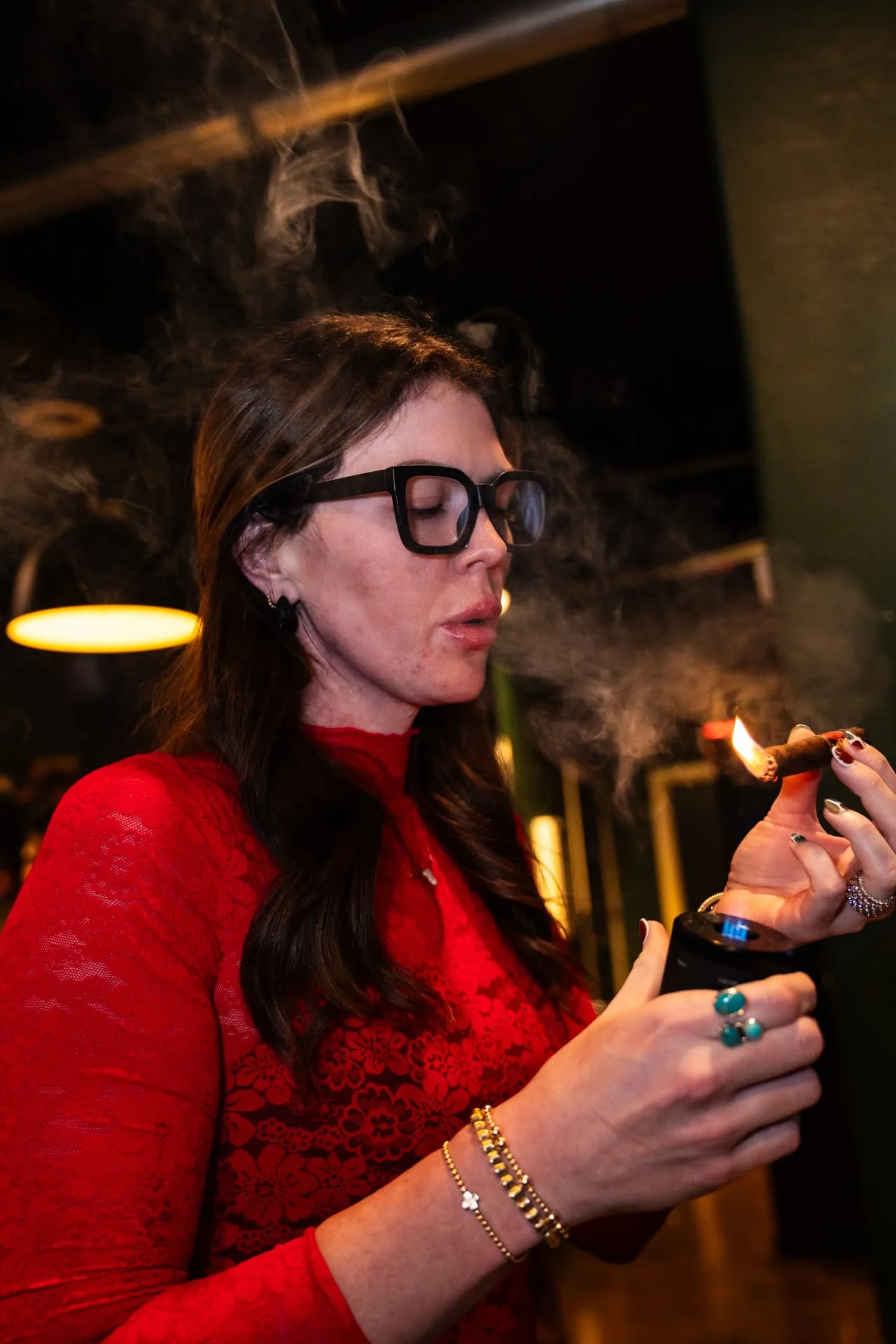Guest lighting a cigar with a torch lighter at Ash & Barrel