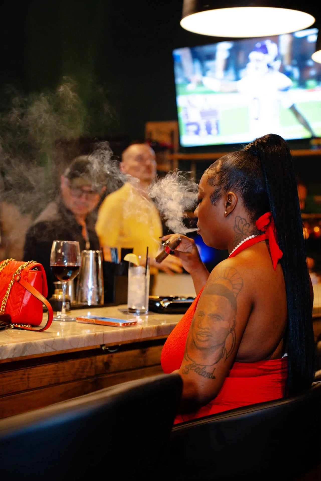 Guest enjoying a cigar and wine at the Ash & Barrel bar